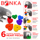 African Grey parrot chewing colorful wooden heart bird toy pieces for enrichment and mental stimulation