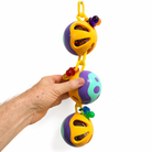 Colorful plastic parrot toy with beads and bells for enrichment, held in hand