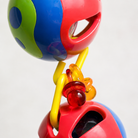 Colorful plastic parrot toy with red, blue, green balls and yellow links for chewing and foraging enrichment.