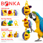 Blue-and-yellow macaw playing with colorful plastic ball bird toy featuring foraging holes and beads