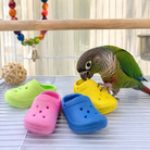 Green parrot playing with colorful plastic clog bird toys inside cage